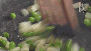 鍋中油7成熱時，入青豆、筍丁翻炒，然后加糯米飯加鹽均勻翻炒。