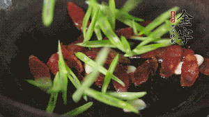 先后下香腸片、四季豆絲均勻翻炒，加適量清水燜煮一下。