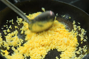 大火加熱炒鍋，再入油，燒到四至五成熱時倒入雞蛋液，在未凝結(jié)之前，加米飯煸炒，不停翻炒并用鍋鏟將成塊的米飯碾開、撥散。