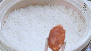 煮開(kāi)后轉(zhuǎn)小火，當(dāng)米飯出現(xiàn)小孔時(shí)，鋪上金字麻辣香腸。