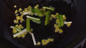 鍋中熱油，依次下姜粒、蔥段、蘆筍炒香。