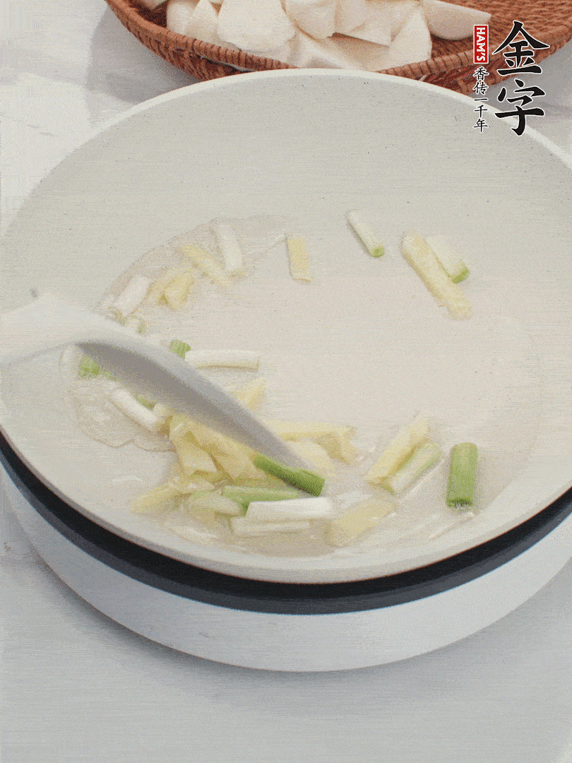 鍋中油五成熱，下蔥白、姜片爆香。