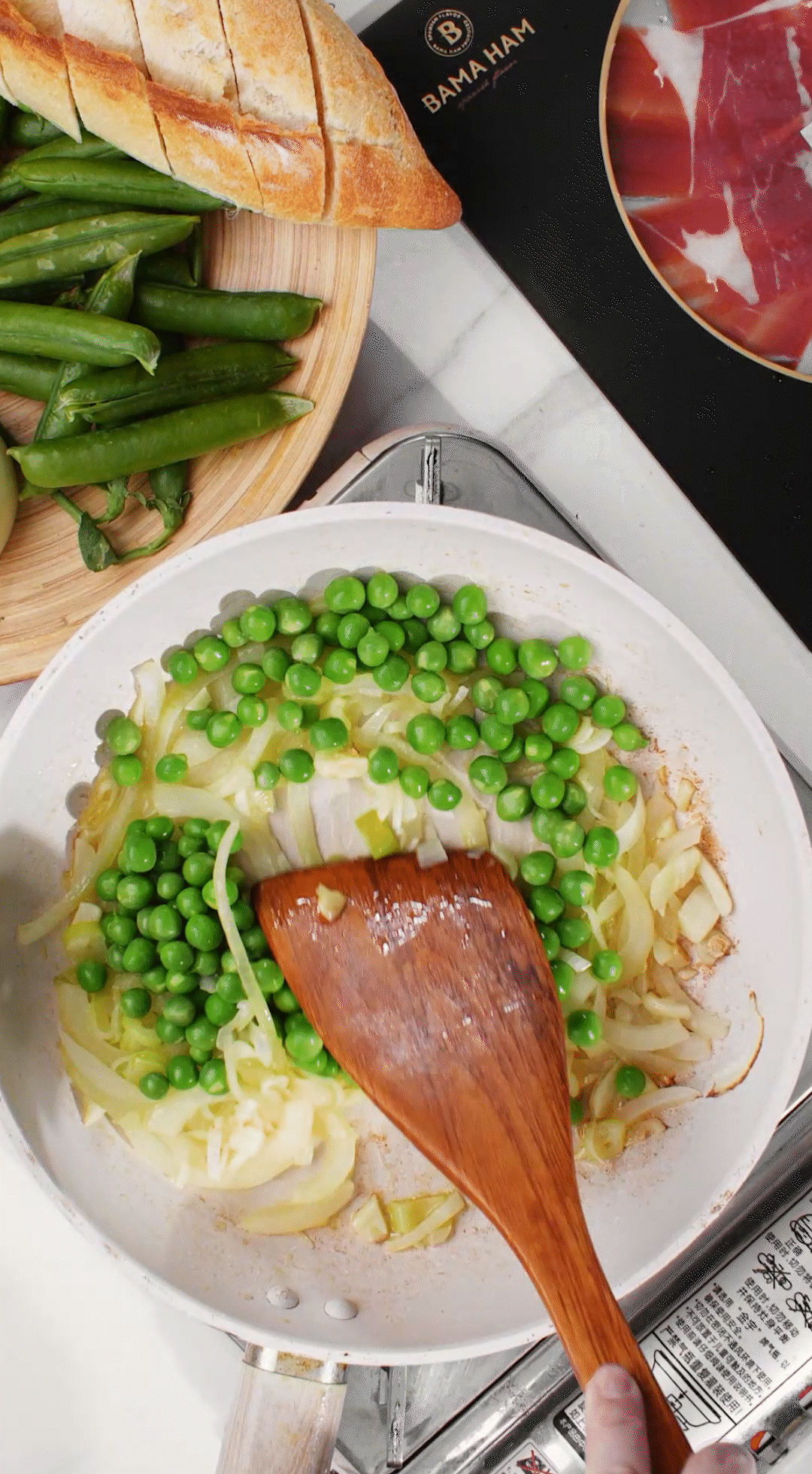 鍋中放入黃油融化，加入洋蔥絲、大蔥蔥白絲、蒜末翻炒變軟出香味。加入剛剛汆燙冰鎮(zhèn)后的豌豆，取出一點(diǎn)點(diǎn)待會(huì)擺盤裝飾用。加一點(diǎn)鹽 (和黑胡椒) 調(diào)味。